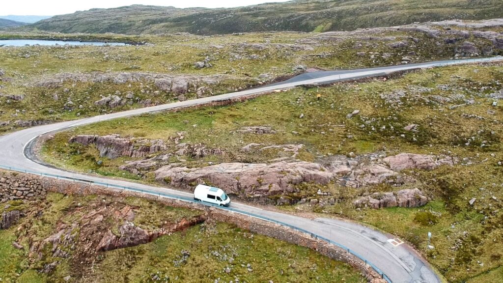 Van Driving down windy road on the south of the NC500