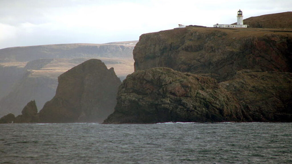 View of Cape Wrath from sea. Lighthouse on top of cliff can be seen. View of west coast of NC500. 