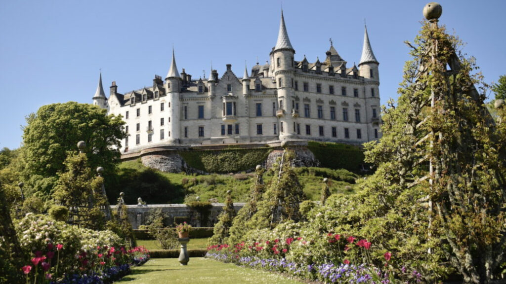 Grand Picturesque castle with beautiful gardens in foreground.