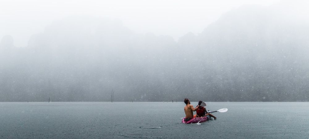 Image of people sea kayaking in the rain. This is one of the unusual things you can do on the Isle of Skye. Photo by Taneli Lahtinen on Unsplash