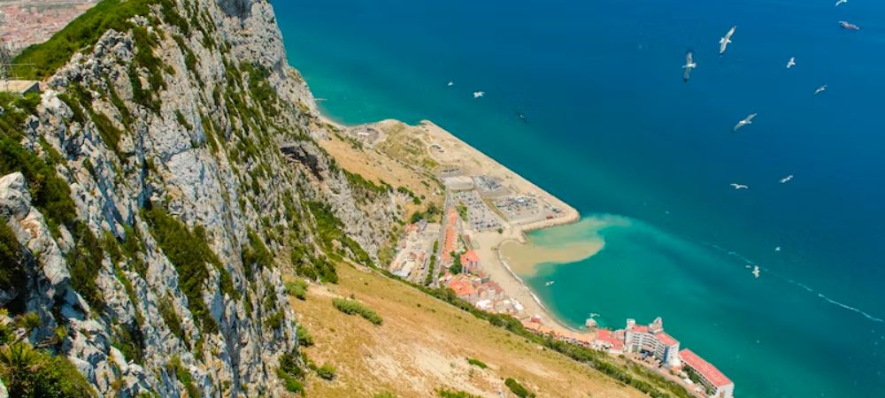 A view of one of the 3 sandy beaches that can be found in Gibraltar. This image is essentially a bird eye image of the beach as it is taken from the top of the rock of Gibraltar. Is it worth visiting Gibraltar?
